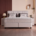 Alice Boxspringbett in Bouclé Beige, Frontansicht mit gepolstertem Kopfteil, Matratze und Topper sowie dekorativen Kissen