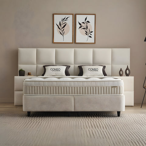 CONSO Boxspringbett in Beige mit Stoffbezug, Frontansicht mit gepolstertem Kopfteil, Matratze und Topper im Schlafzimmer