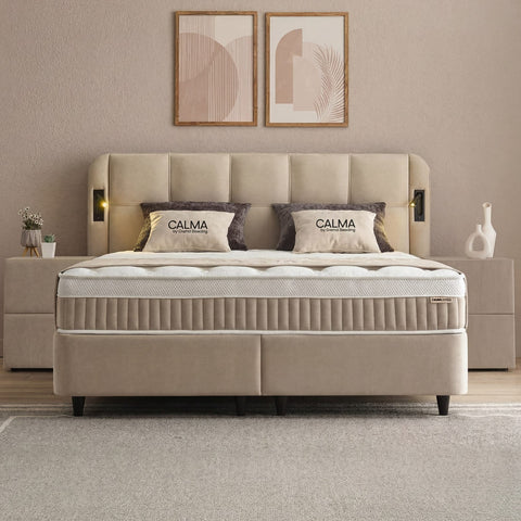 Calma Boxspringbett in Beige mit Stoffbezug, Frontansicht mit gepolstertem Kopfteil, Matratze und Topper im Schlafzimmer