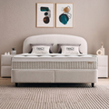 Fancy Boxspringbett in Beige aus Samt Velours, Frontansicht mit gerundetem Kopfteil, Matratze und Fancy-Kissen im hellen Schlafzimmer