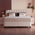 Sydney Boxspringbett in Samt Velours Beige, Frontansicht mit gestepptem Kopfteil, Matratze und Topper im Schlafzimmer