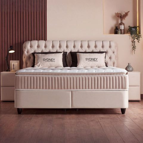Sydney Boxspringbett in Samt Velours Beige, Frontansicht mit gestepptem Kopfteil, Matratze und Topper im Schlafzimmer