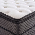 Nahaufnahme der Matratzenecke mit weissem Topper und grauem Steppbezug