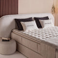 Brooklyn Boxspringbett Detail in Samt Beige, gesteppter Topper und Kissen am gepolsterten Kopfteil, Nahaufnahme Liegefläche