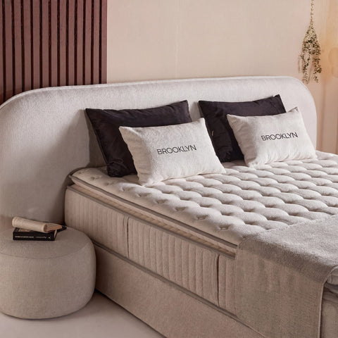 Brooklyn Boxspringbett Detail in Samt Beige, gesteppter Topper und Kissen am gepolsterten Kopfteil, Nahaufnahme Liegefläche