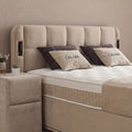 Kopfteil-Detail des Calma Boxspringbett in beigem Stoff mit Steppung, Zierkissen und Matratze mit Topper