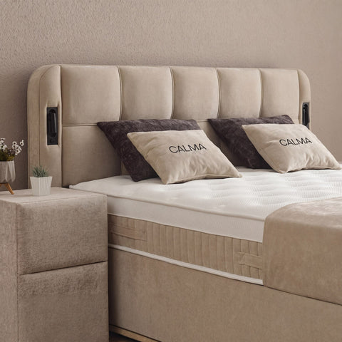 Kopfteil-Detail des Calma Boxspringbett in beigem Stoff mit Steppung, Zierkissen und Matratze mit Topper