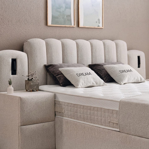 Dream Boxspringbett Detail vom gepolsterten Kopfteil in beigem Stoff mit Kissen, Matratze und Topper Nahaufnahme
