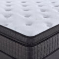 Nahaufnahme weisser Matratzentopper mit Steppung auf grauem Boxspring Unterbau