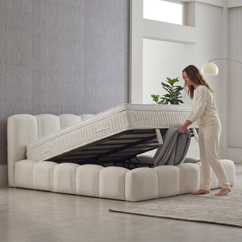 Kaona Boxspringbett mit geöffnetem Bettkasten in Teddy Bouclé Beige – viel Stauraum unter der hochklappbaren Matratze