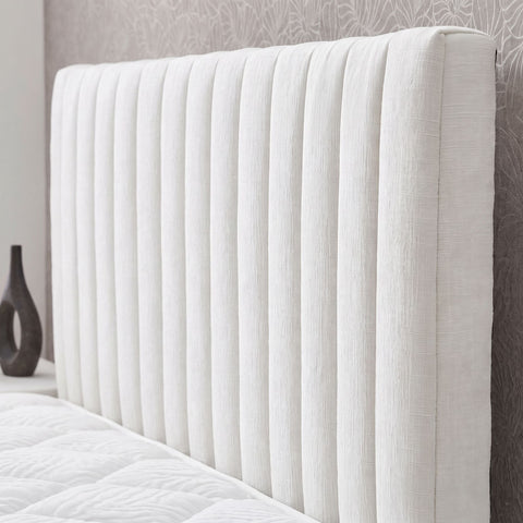 Nahaufnahme des cremefarbenen Boxspringbett Kopfteils mit vertikaler Kanalsteppung