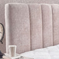 Nahaufnahme des Kopfteils vom Lucia Boxspringbett mit vertikaler Kanalsteppung in grau beigem Strukturstoff