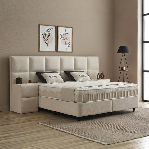 CONSO Boxspringbett Beige seitlich im Raum, Stoffbezug, Kopfteil mit Kissen, Matratze und Topper für hohen Liegekomfort