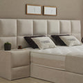 CONSO Boxspringbett Detail vom beigen Stoff-Kopfteil mit Kissen, Nahaufnahme von Bezug, Matratze und Topper