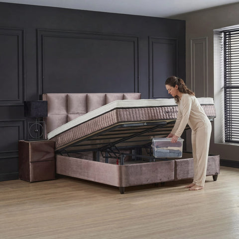 Phantom Boxspringbett mit geöffnetem Bettkasten, Frau nutzt praktischen Stauraum unter der Matratze, Webstoff Beige
