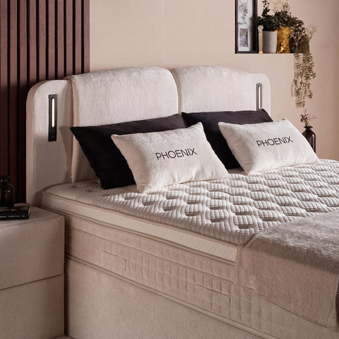 Phoenix Boxspringbett Detail vom Bouclé Kopfteil in Beige mit Kissen und gestepptem Topper, Nahaufnahme des Liegekomforts