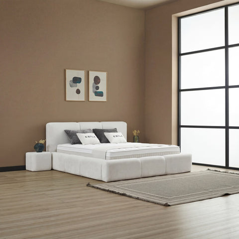 Esila Boxspringbett aus Stoff in Creme, Schlafzimmer-Szene mit Kopfteil, Matratze und Topper in heller Umgebung