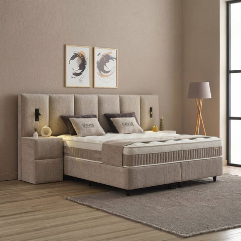 Davis Boxspringbett Stoff Beige in Schräg-Seitenansicht mit gepolstertem Kopfteil, Matratze und Nachtkonsole