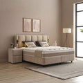 Calma Boxspringbett Beige aus Stoff in heller Schlafzimmer-Szene, seitliche Ansicht mit Kopfteil, Matratze und Nachttisch