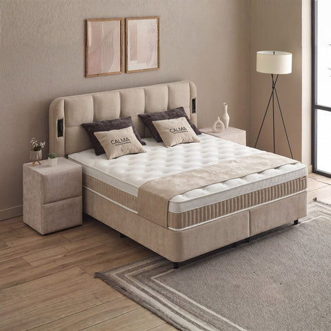 Calma Boxspringbett Beige mit Stoffbezug, seitliche Gesamtansicht mit Matratze, Topper und Kopfteil im Wohnraum