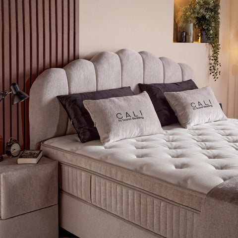 Detail vom Cali Boxspringbett, getuftete Matratze mit Topper und Samt-Kopfteil in Beige mit dekorativen Kissen
