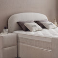Detail vom gerundeten Kopfteil des Fancy Boxspringbetts in Samt Velours Beige, Matratze mit Topper und Fancy-Kissen im Nahblick