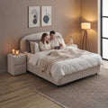 Paar entspannt auf dem Fancy Boxspringbett in Samt Velours Beige, gemütliche Schlafzimmer-Szene mit Nachttisch und warmem Licht