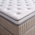 Nahaufnahme Boxspringbett Ecke mit weissem gestepptem Topper und beigem Webstoff Bezug