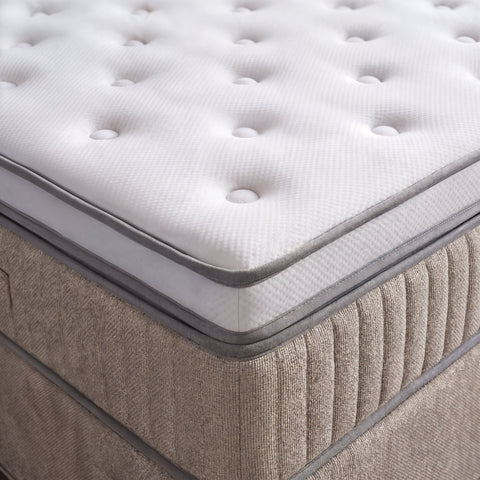 Nahaufnahme Boxspringbett Ecke mit weissem gestepptem Topper und beigem Webstoff Bezug
