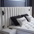 Kopfteil-Detail des Sheraton Boxspringbetts in Bouclé Weiss mit vertikaler Steppung, integrierten Leselampen und Kissen