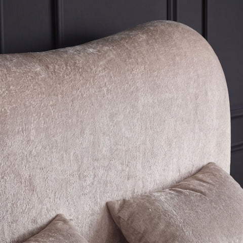 Nahaufnahme des beigen Teddy Bezugs am gerundeten Kopfteil des Boxspringbetts