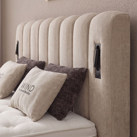 Nahaufnahme beiges Boxspringbett Kopfteil mit vertikaler Kanalsteppung und schwarzem Griff