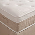 Nahaufnahme Matratzenecke mit weissem Waffelstoff Topper auf beigem Boxspringbett Unterbau