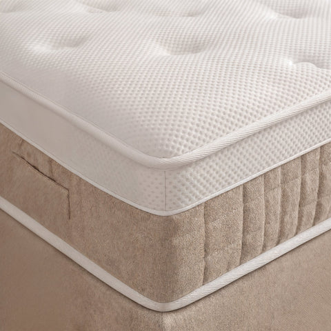 Nahaufnahme Matratzenecke mit weissem Waffelstoff Topper auf beigem Boxspringbett Unterbau